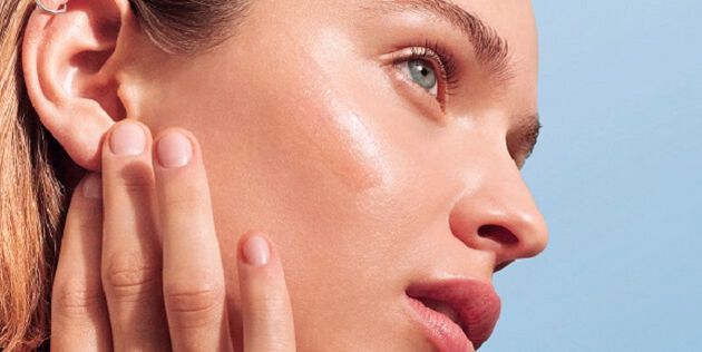Femme se massant le visage avec un serum &agrave; l'acide hyaluronique