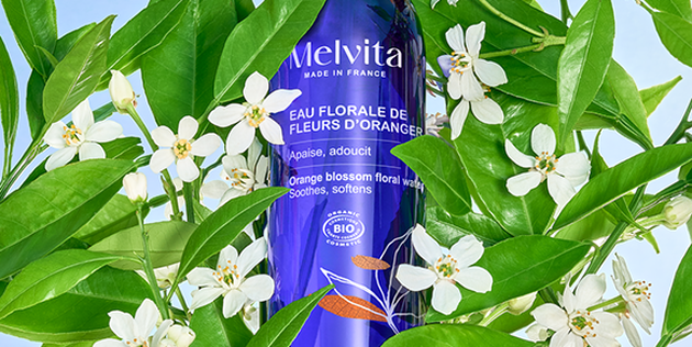 Femme qui applique de l'eau florale de rose sur son visage