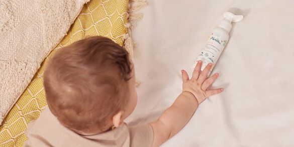 b&eacute;b&eacute; vu de dos qui touche un soin avec sa main droite