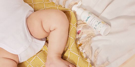 vue d'une jambe d'un b&eacute;b&eacute; avec un soin melvita &agrave; sa droite