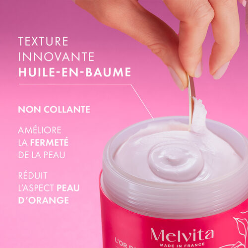 Agrandir la vue4/6 de Zoom sur une main qui pr&eacute;l&egrave;ve la texture onctueuse du produit. A gauche "Texture innovante huile-en-baume". En dessous "Non collante", en dessous "am&eacute;liore la fermet&eacute; de la peau", en dessous "R&eacute;duit l'aspect peau d'orange"
