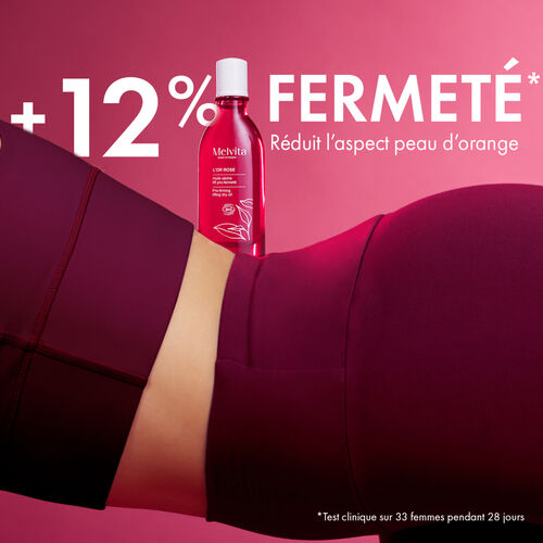 Agrandir la vue2/11 de Au centre, l'huile tient sur le dos d'une femme. En haut du visuel en blanc "+12% fermet&eacute;*" en majuscule. En dessous, en plus petit,"R&eacute;duit l'aspect peau d'orange". En bas du visuel &agrave; droit est &eacute;crit en petit "Test clinique sur 33 femmes pendant 28 jours"