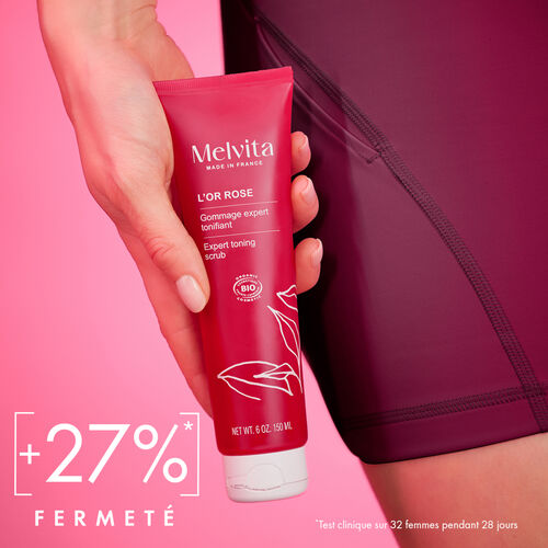 Agrandir la vue2/7 de Une main tient le gommage. En bas &agrave; gauche en blanc est &eacute;crit "+27% fermet&eacute;*". En bas &agrave; droite est &eacute;crit en blanc et plus petit "Test clinique 32 femmes pendant 28 jours"