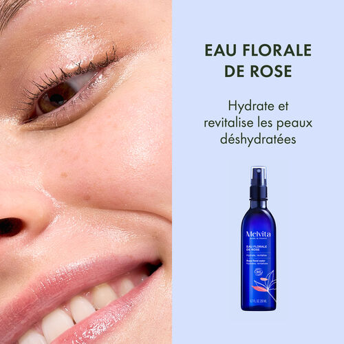 Agrandir la vue4/8 de Le visuel est coup&eacute; en deux. A gauche, zoom sur le visage d'une femme qui sourit. A droite, sur un fond bleu clair, "EAU FLORALE DE ROSE", en dessous "Hydrate et revitalise les peaux d&eacute;shydrat&eacute;es". En dessous, le packshot du produit.