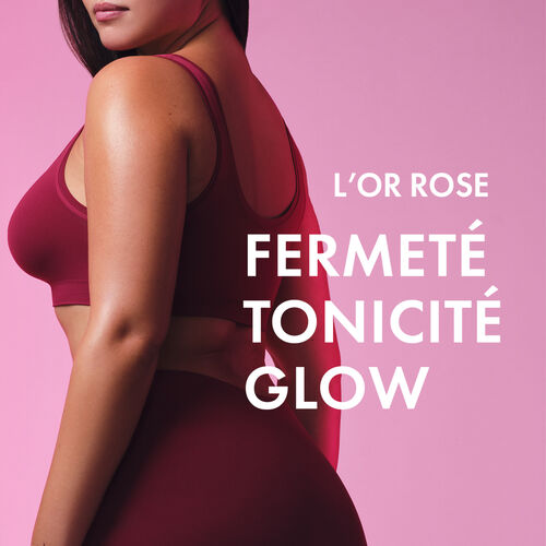 Agrandir la vue11/11 de Focus sur le corps d'une femme de c&ocirc;t&eacute; portant un ensemble de sport rose fonc&eacute;. A droite de ce corps est &eacute;crit en majuscule "L'OR ROSE", en dessous est &eacute;crit en majuscule 3 mots les uns en dessous des autres "Fermet&eacute;, tonicit&eacute;, glow"