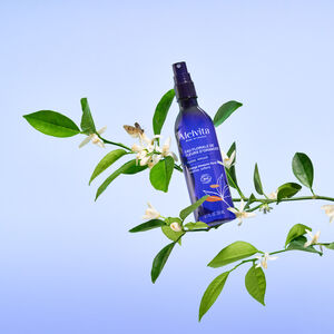 Eau Florale De Fleurs D'Oranger Bio 200 ml, La bouteille est posée sur une branche de Bigaradier, l'arbre qui crée les fleurs d'oranger | Melvita